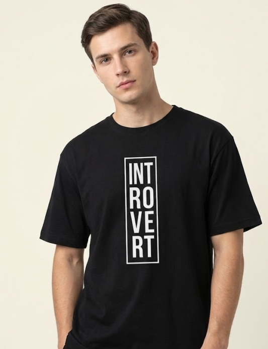 Man wearing a black t-shirt with 'INTROVERT' text on a beige background