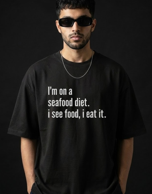 Man wearing a black t-shirt with a humorous text design on a dark background